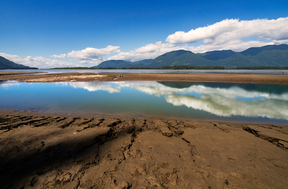 Clouds reflecting in a pool on the Fraser River in Chilliwack